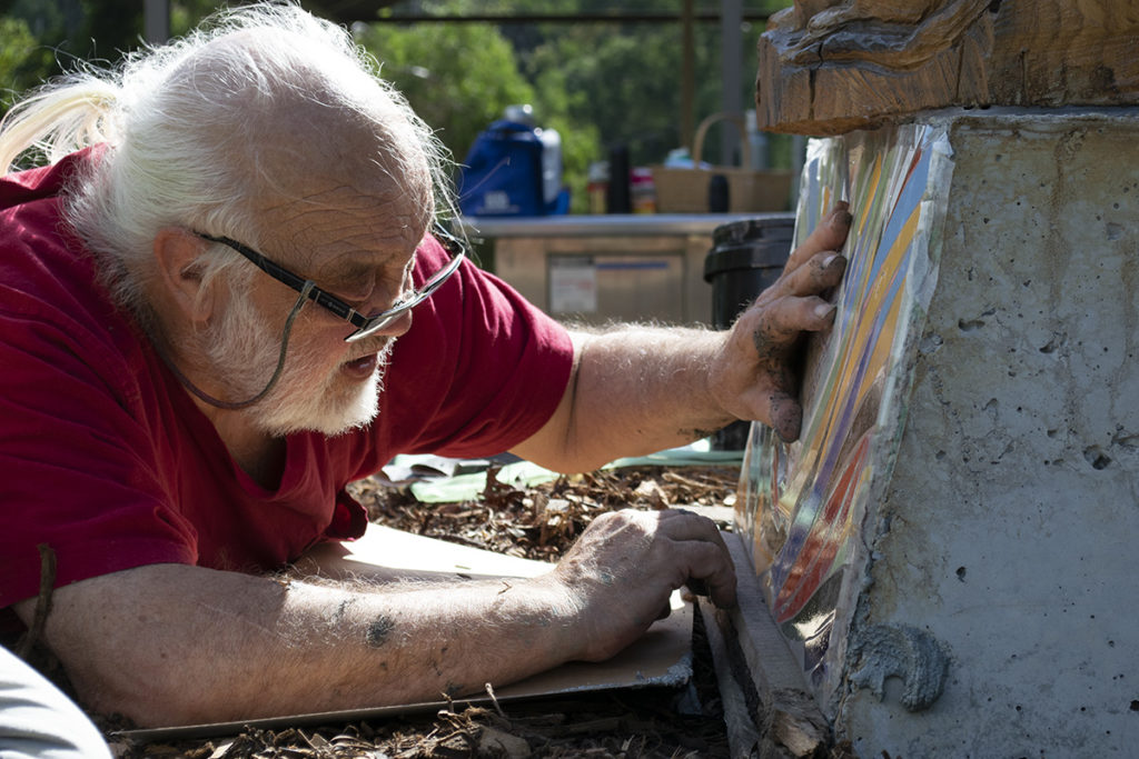 Local artist Franc Smith placing mosaics on the sculpture base